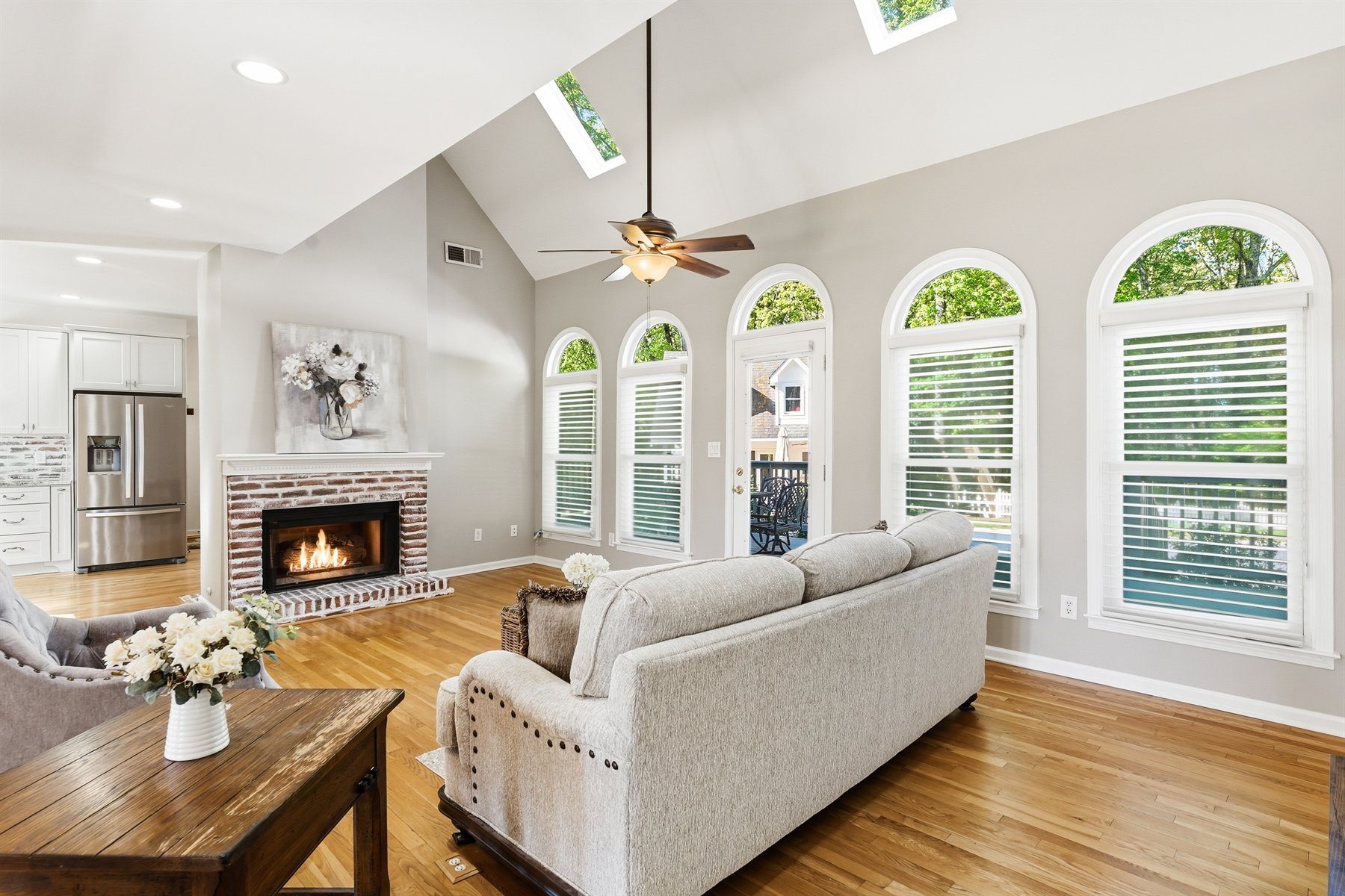 Vaulted living room with tall arched windows and fireplace